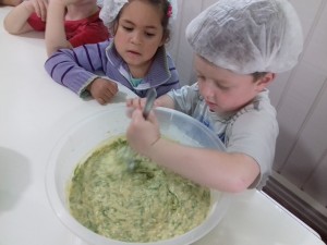 Alunos auxiliando no preparo do bolinho de alface. 