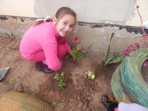 Aluna Camila, da Com-Vida, fazendo o plantio das mudinhas de flores que trouxe de casa.